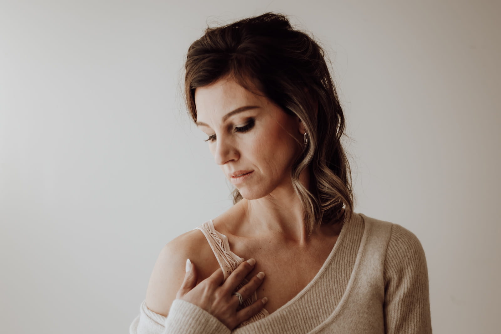 Vrouw in zachte lingerie en los truitje tijdens boudoirshoot in Beveren